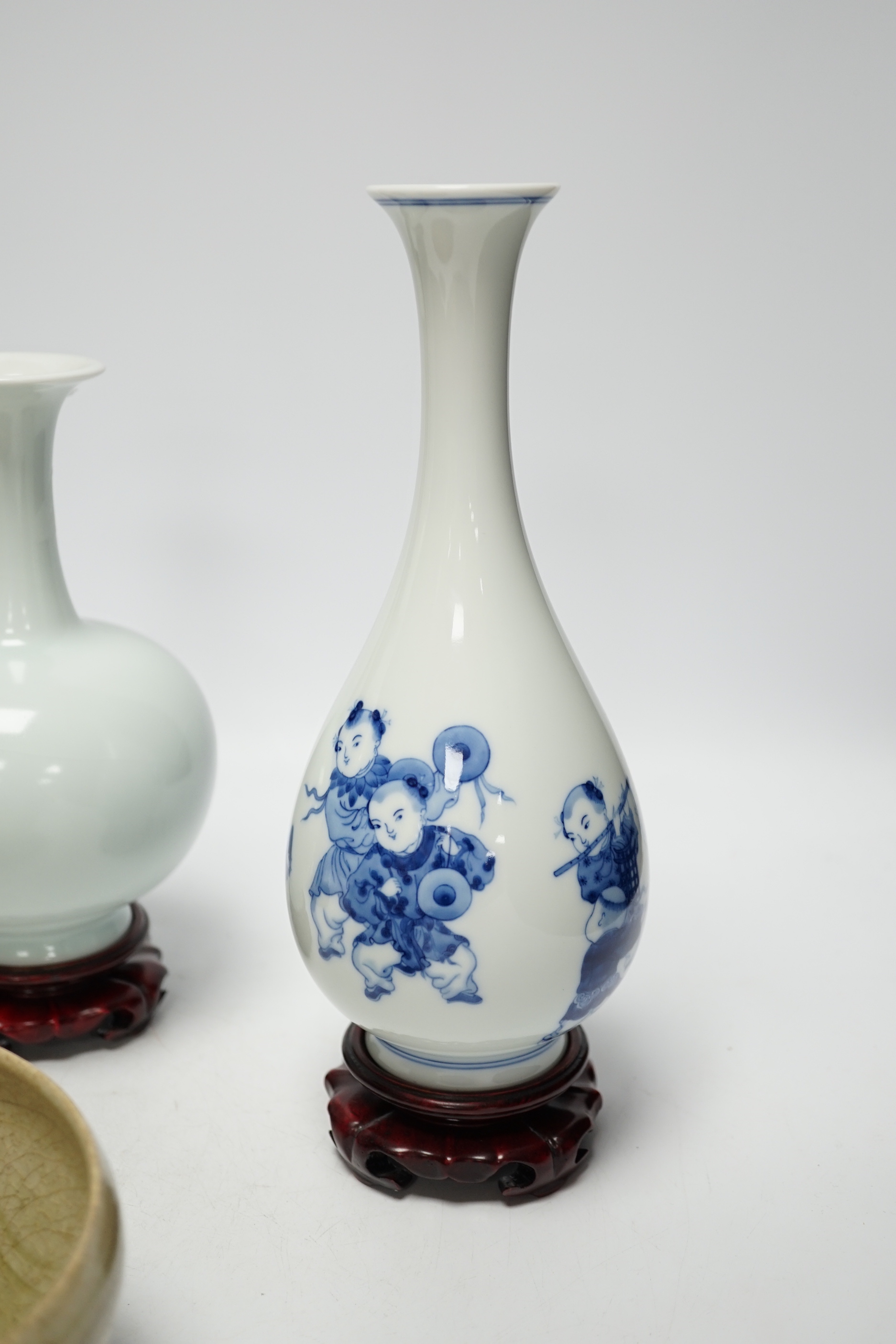 Two modern Chinese blue and white vases on stands, a crackle glaze celadon bowl and vase, tallest 26cm including stand